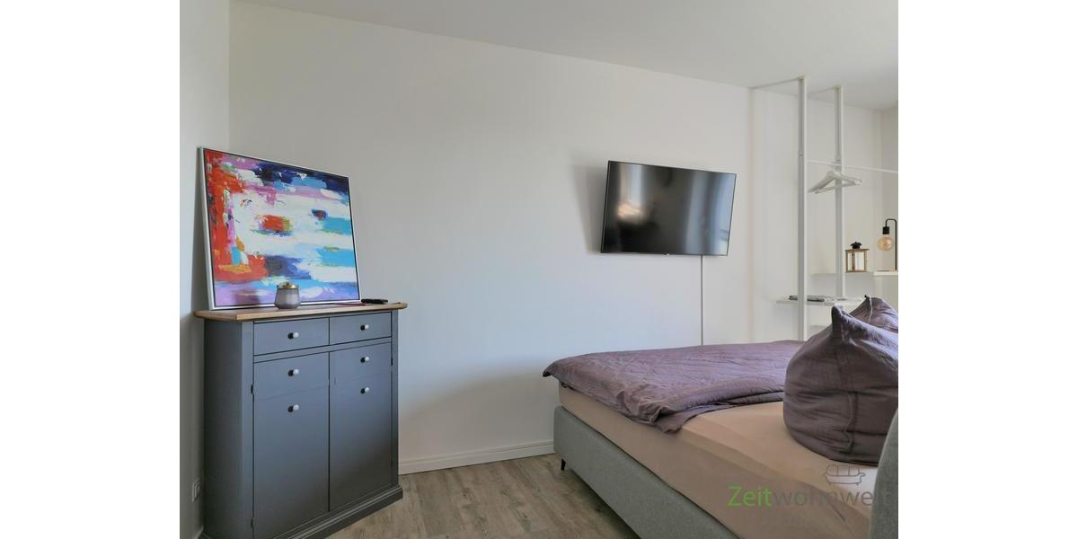 Kommode und Bett hinter dem Raumteiler