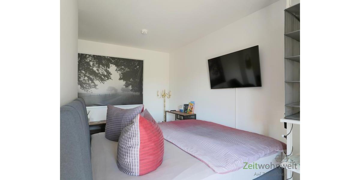Bett und TV hinter dem Raumteiler