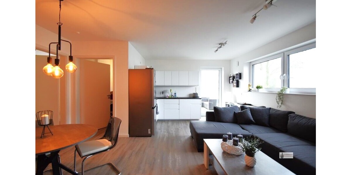 Wohnzimmer mit offener Küche und Terrassentür
