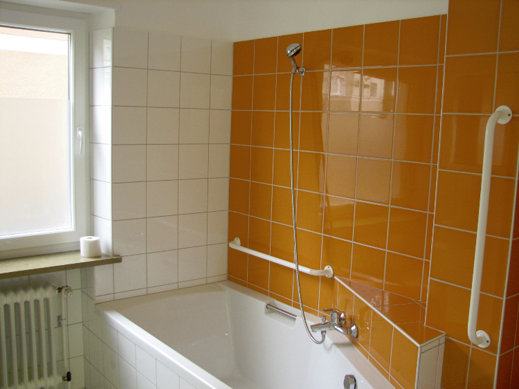 Sonniges Badezimmer mit Badewanne und Dusche