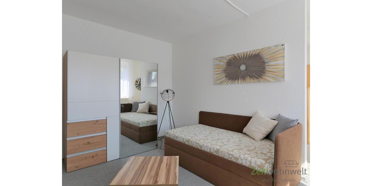 Schlafcouch und verspiegelter Kleiderschrank