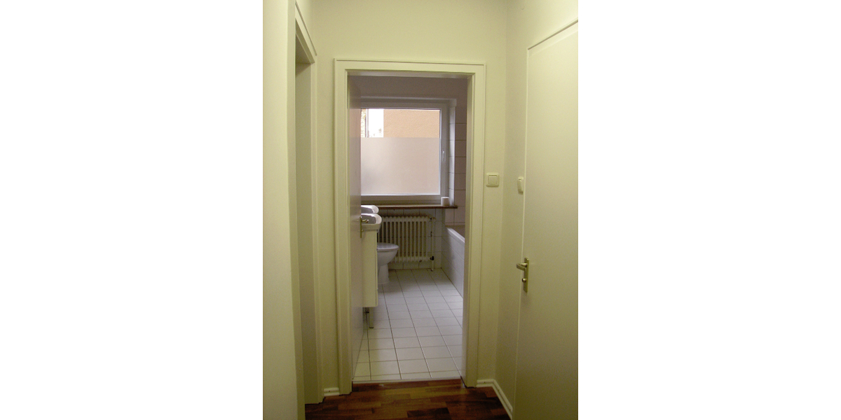 Ansicht Badezimmer vom Flur mit Gäste-WC Türe rechts
